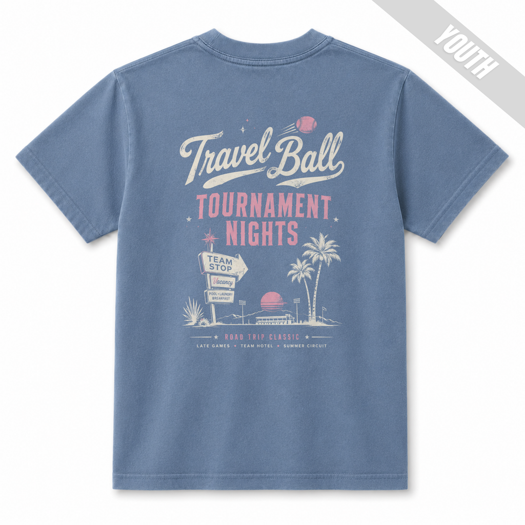 Back view of a Washed Denim youth baseball T-shirt featuring a large vintage Travel Ball Tournament Nights design with palm trees, a team stop sign, and retro tournament graphics.